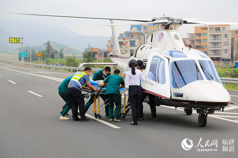 高速交警与医务人员将重伤员抬上直升机 邹家骅摄